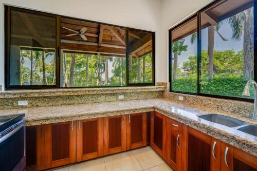 a kitchen with a sink and two windows at Casa Carmen in Potrero