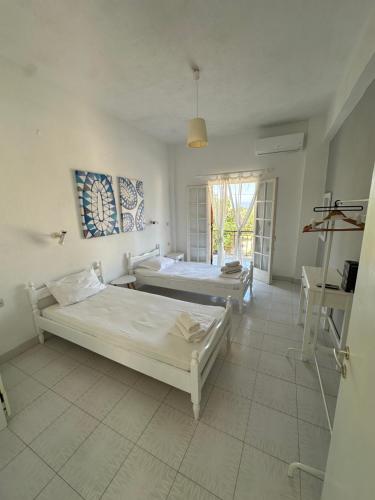 a bedroom with two beds and a window at Olive terra holiday aparments in Lefkimmi
