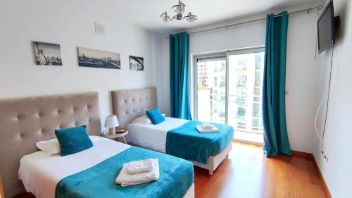 a bedroom with two beds and a window at Vista Mar Concórdia by Rentallido in Funchal