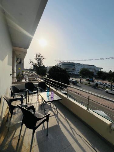 a balcony with chairs and a table on a building at Royal Stays 2Bed Cozy Apartment in Multan