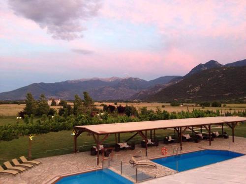 a resort with a pool and mountains in the background at Ktima Kletsa in Graviá