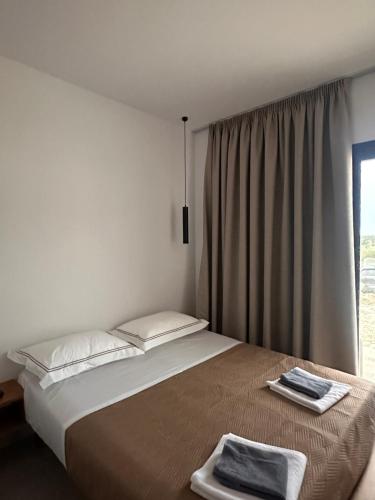 a bedroom with a large bed and a window at Escape by Ambelas in Himare