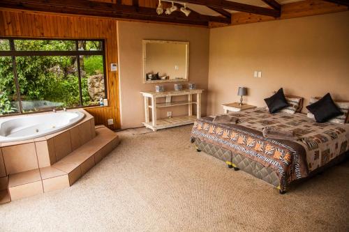 a bedroom with a bed and a bath tub at The Stix in Dullstroom