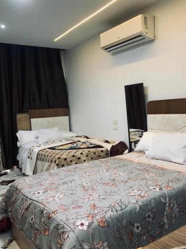 a hotel room with two beds and a fan at Studio in Porto Said Compound in Port Said