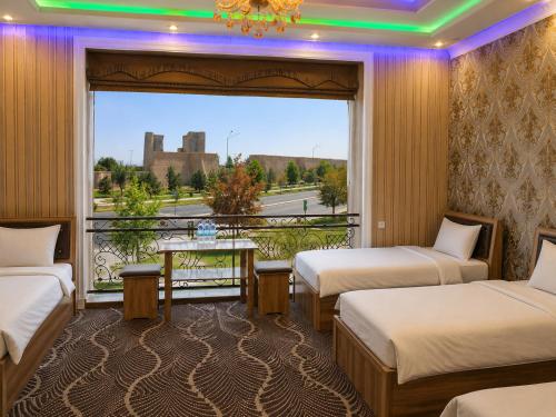 a room with two beds and a window with a view at Zamin Hotel in Shahrisabz