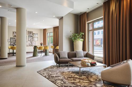 a living room with a couch and a table at NH Collection Nürnberg City in Nuremberg