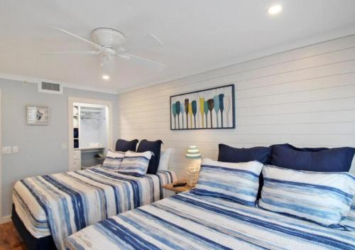 two beds with striped sheets in a bedroom at GBB 1335 Stunning Harbor View Condo on Siesta Key in Siesta Key