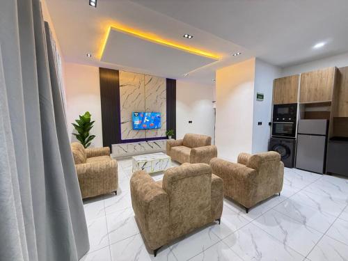a living room with chairs and a tv in it at Esthella Property in Ijaiye