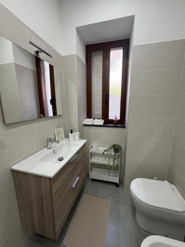 a bathroom with a sink and a toilet and a mirror at La dimora dei Giglianti in Brusciano
