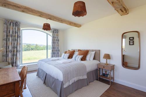 a bedroom with a large bed and a window at Scenic Barn Conversion in Rural Shropshire in Craven Arms