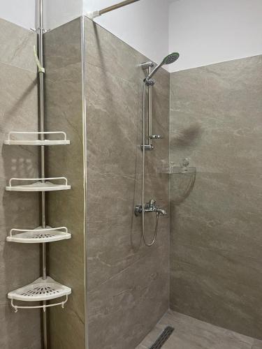 a shower with a glass door in a bathroom at Berat Central Home in Berat