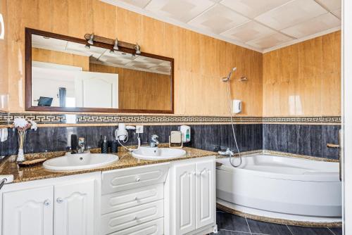 a bathroom with two sinks and a bath tub and a tubermott at Punta Prima Apartments by 3VILLAS in Punta Prima