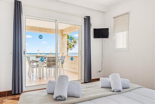 a bedroom with a bed and a view of the ocean at Punta Prima Apartments by 3VILLAS in Punta Prima