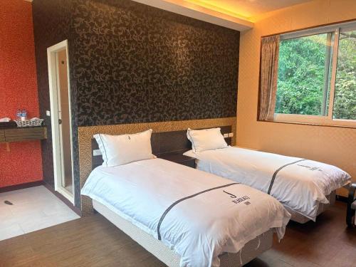 a room with two beds and a window at BlackJazz Inn in Puli