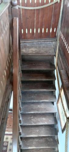 a wooden staircase in a building with a wooden bench at Casa cu Turn in Sărata-Monteoru