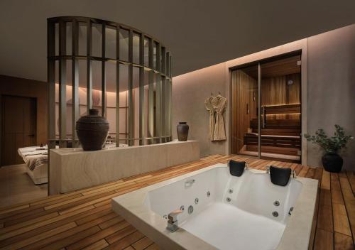 a large bathroom with a bath tub in a room at Akra Didim Resort & SPA in Didim
