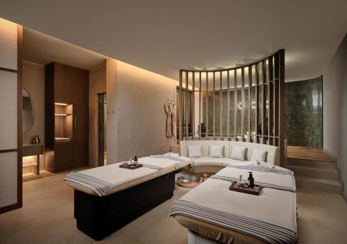 a room with two beds in a room with a couch at Akra Didim Resort & SPA in Didim