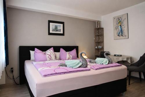 a bedroom with a large bed with two swans on it at Hotel Garni in Burghausen