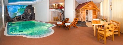 una piscina en una habitación con mesa y sillas en Grand Hall Hotel, en Yekaterinburg