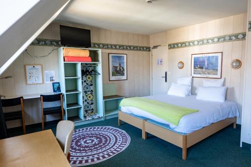 a bedroom with a bed and a desk and a table at L'Auberg'ine - Maison Glenn Anna in Sainte Anne d'Auray