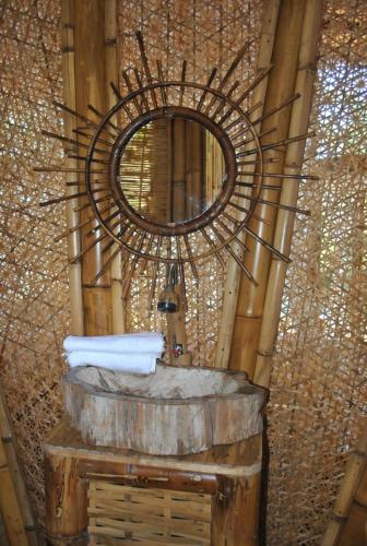 a bathroom with a large mirror and a sink at Le Caveau de lemuriens in Nosy Be