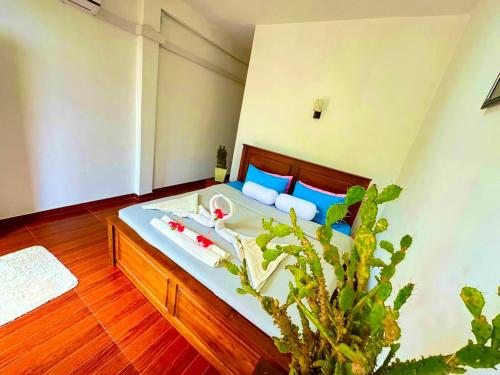 a bedroom with a bed with blue pillows and a plant at Emerald mirror guest Ella in Ella