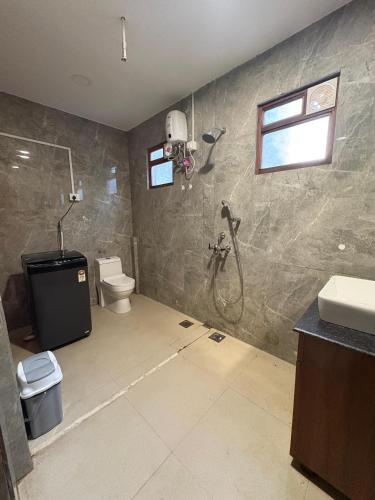 a bathroom with a shower and a toilet at Simple Belle Stay ,Pool &Bar in Vagator
