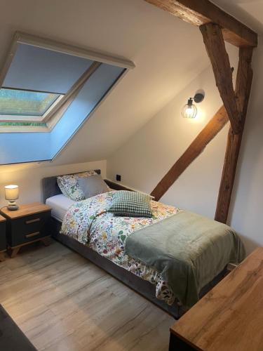 a bedroom with a bed in the attic at Agroturystyka u Iwony in Wiekowo