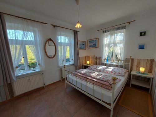 a bedroom with a bed and two windows at Lotsenwohnung B-9 in Butjadingen