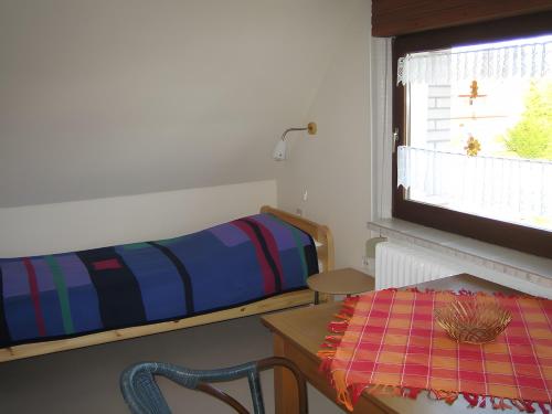 a room with a bed and a table and a window at Ankerplatz H-7 in Butjadingen
