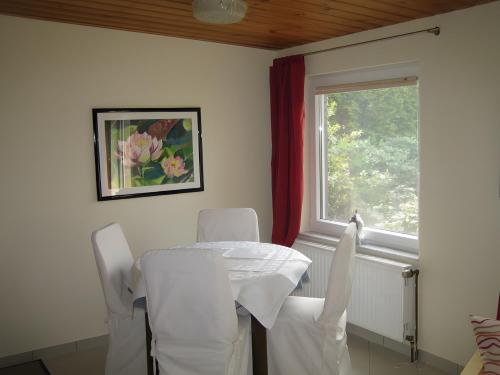 a dining room with a table and chairs and a window at Kajüte H-8 in Butjadingen