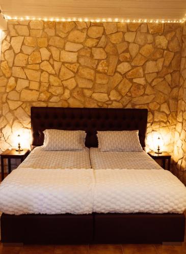 a bedroom with a bed with a stone wall at Quinta Cabecinha in Penela