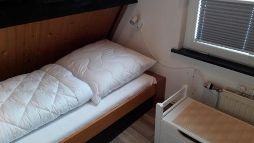 a small bed in a small room with a window at Haus Maya H-12 in Butjadingen