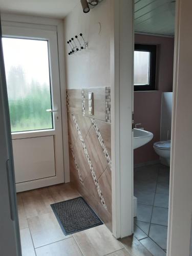 a bathroom with a shower and a toilet and a sink at Haus Maya H-12 in Butjadingen