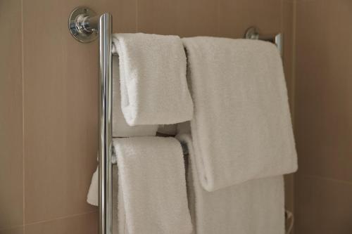 a group of white towels hanging in a shower at L’Horizon Beach Hotel & Spa in St. Brelade