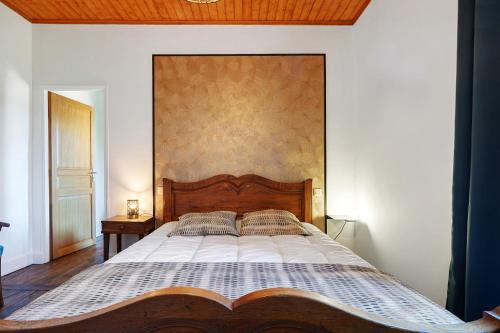a bedroom with a large bed with a wooden headboard at Maison De Campagne in Ligneyrac