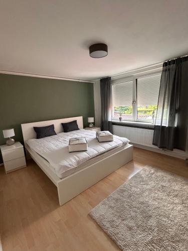 a bedroom with a large white bed and a window at Strandläufers Ruhe in Wiepkenhagen
