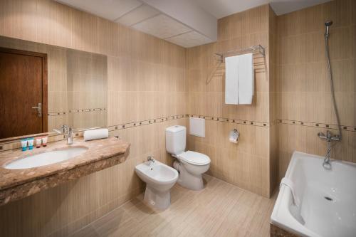 ein Badezimmer mit Waschbecken, Toilette und Badewanne in der Unterkunft Hotel Alba - All inclusive in Sonnenstrand