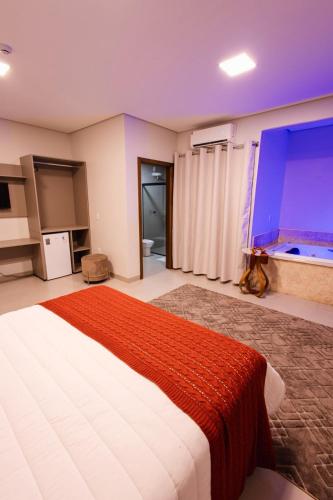 a bedroom with a large bed and a large window at Hotel Golden Palace in Fonte Termal Água Quente