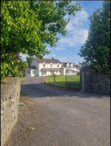 a large house with a gate and a stone wall at Oyster Lodge shared accomadation in Galway