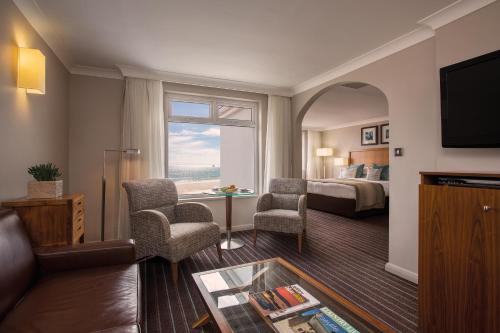 a hotel room with a bed and a living room at L’Horizon Beach Hotel & Spa in St. Brelade
