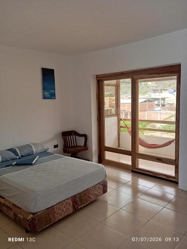 a bedroom with a bed and a sliding glass door at Yemayá hostal in Puerto López