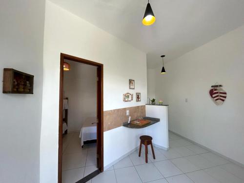 a room with a table and a refrigerator and a chair at Pousada Oceano Atlântico in Barra Grande