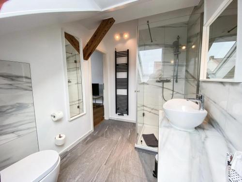 a white bathroom with a sink and a toilet at Ferienwohnung König in Brandenburg an der Havel