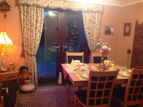a dining room with a table with a teddy bear on it at The Cedars House B&B in Nuneaton