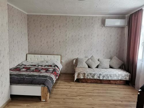 a bedroom with two beds and a window and a bedskirts at Студио Търговище in Targovishte