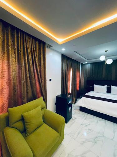 a bedroom with a bed and a green couch at Soilsmart Haven in Abuja