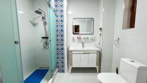 a bathroom with a shower and a sink and a toilet at Mashkobi Buxoro in Bukhara