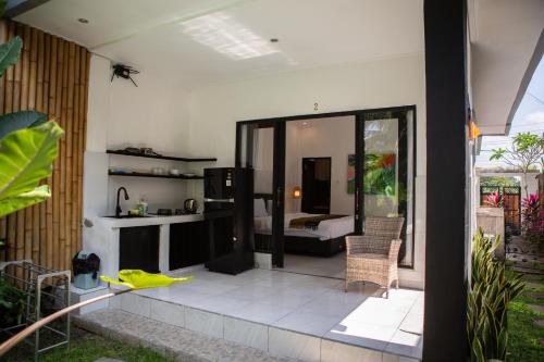 a room with a patio with a bed in the background at Parafrutts Apartments by Ateliero in Ubud