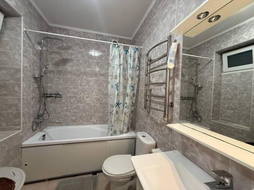 a bathroom with a tub and a toilet and a sink at Apart 26 in Odesa